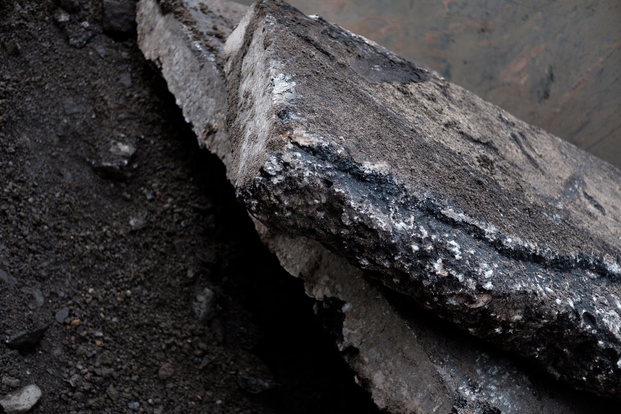 Broken concrete slab on dark soil ground
