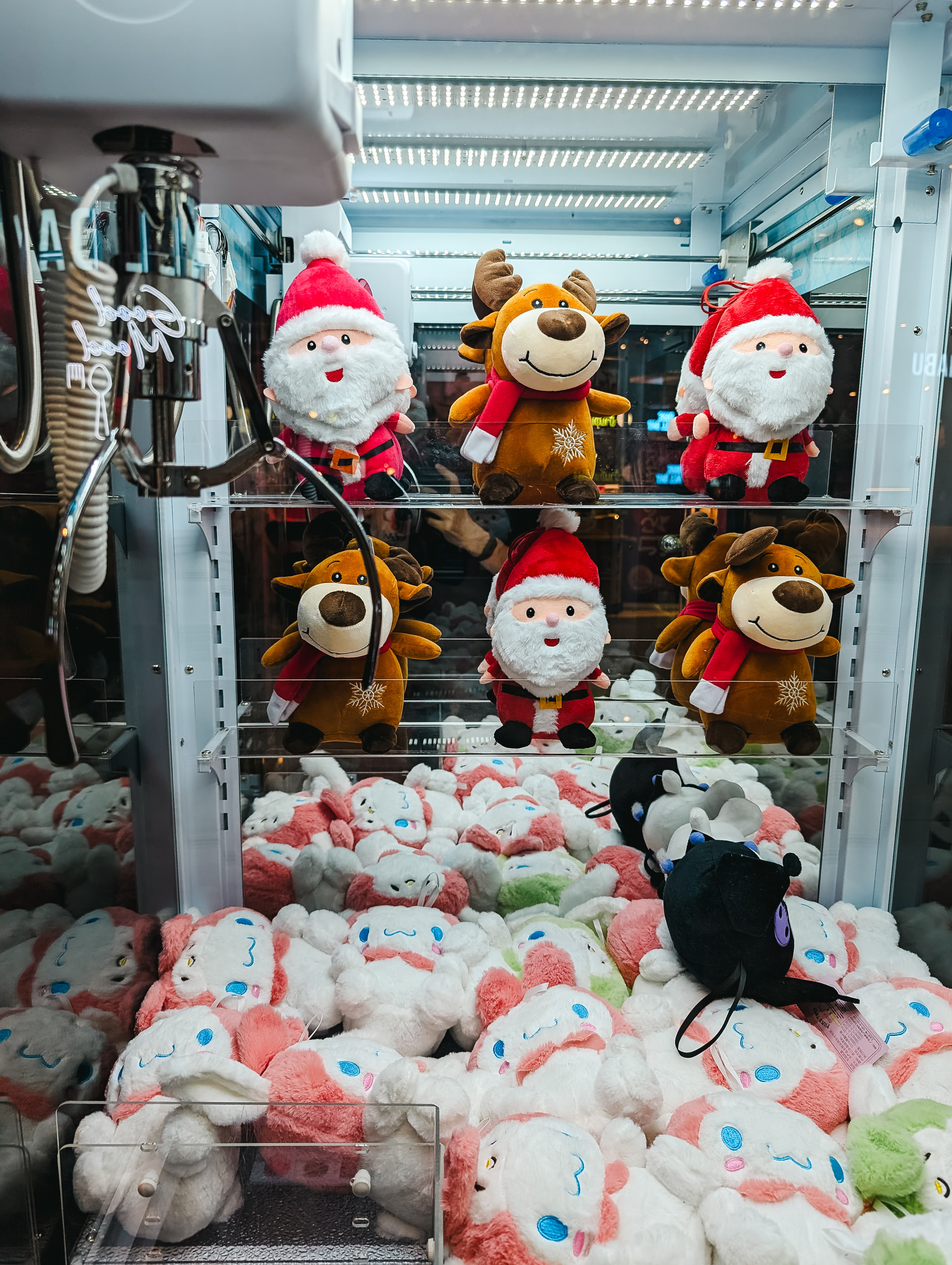 Christmas claw machine filled with Santa Claus and reindeer plush toys
