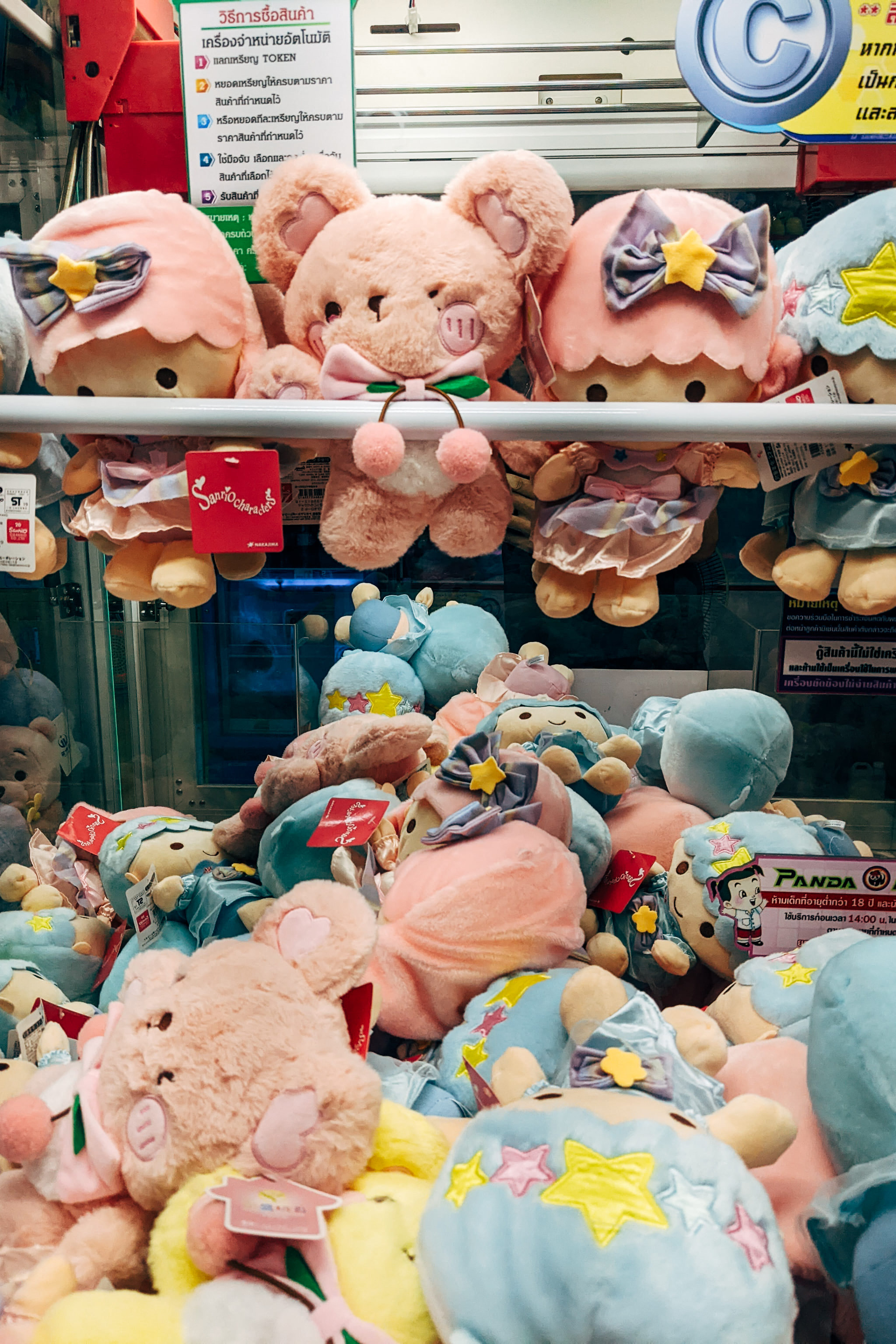 Claw machine filled with pink and blue plush toys