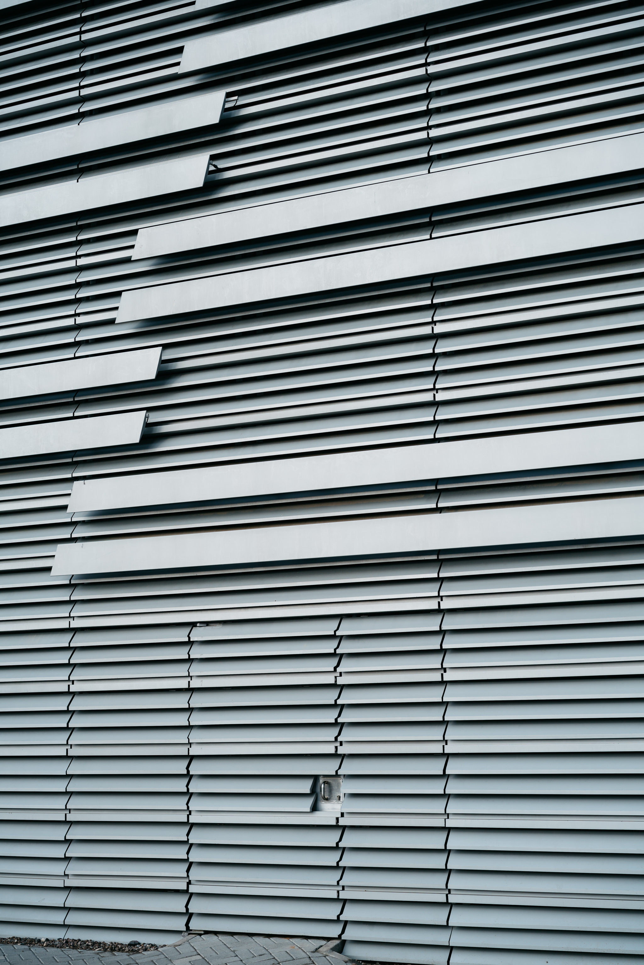 Modern building facade with horizontal metal slats in abstract pattern