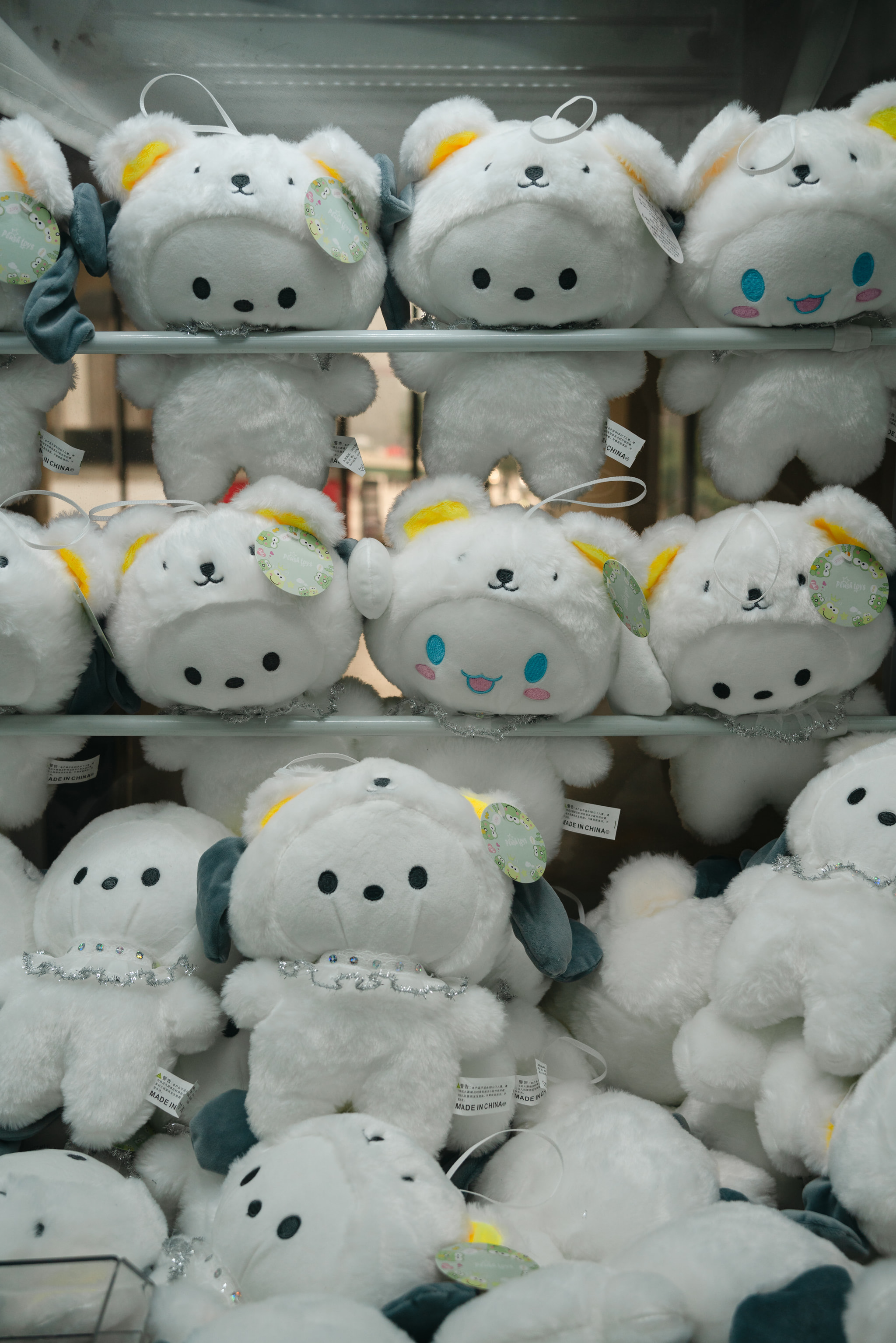 Rows of white plush character toys with glittery details displayed on store shelving.