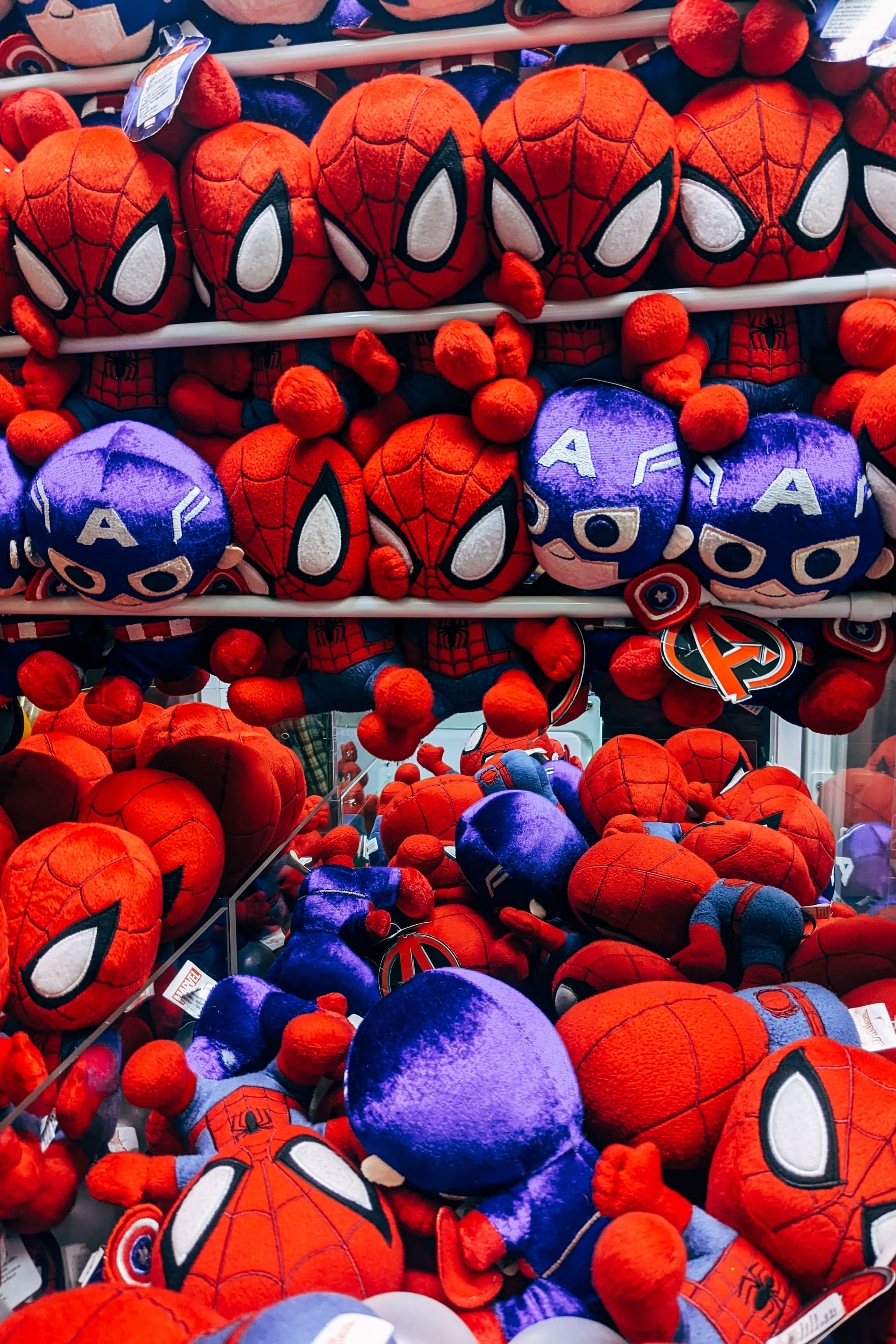 Pile of Spider-Man and Captain America plush toys on store shelves