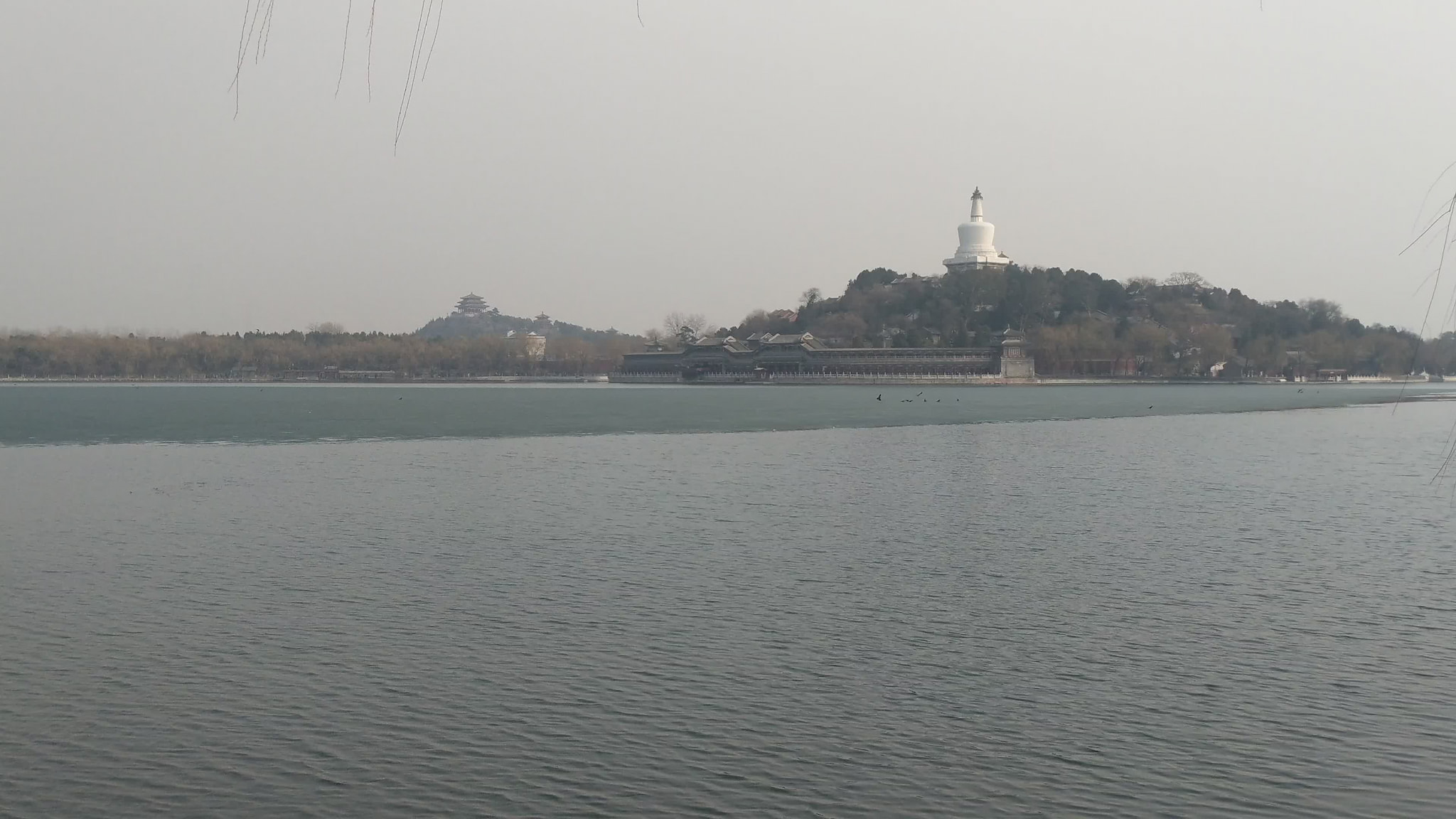 White pagoda overlooking frozen lake in Beijing park