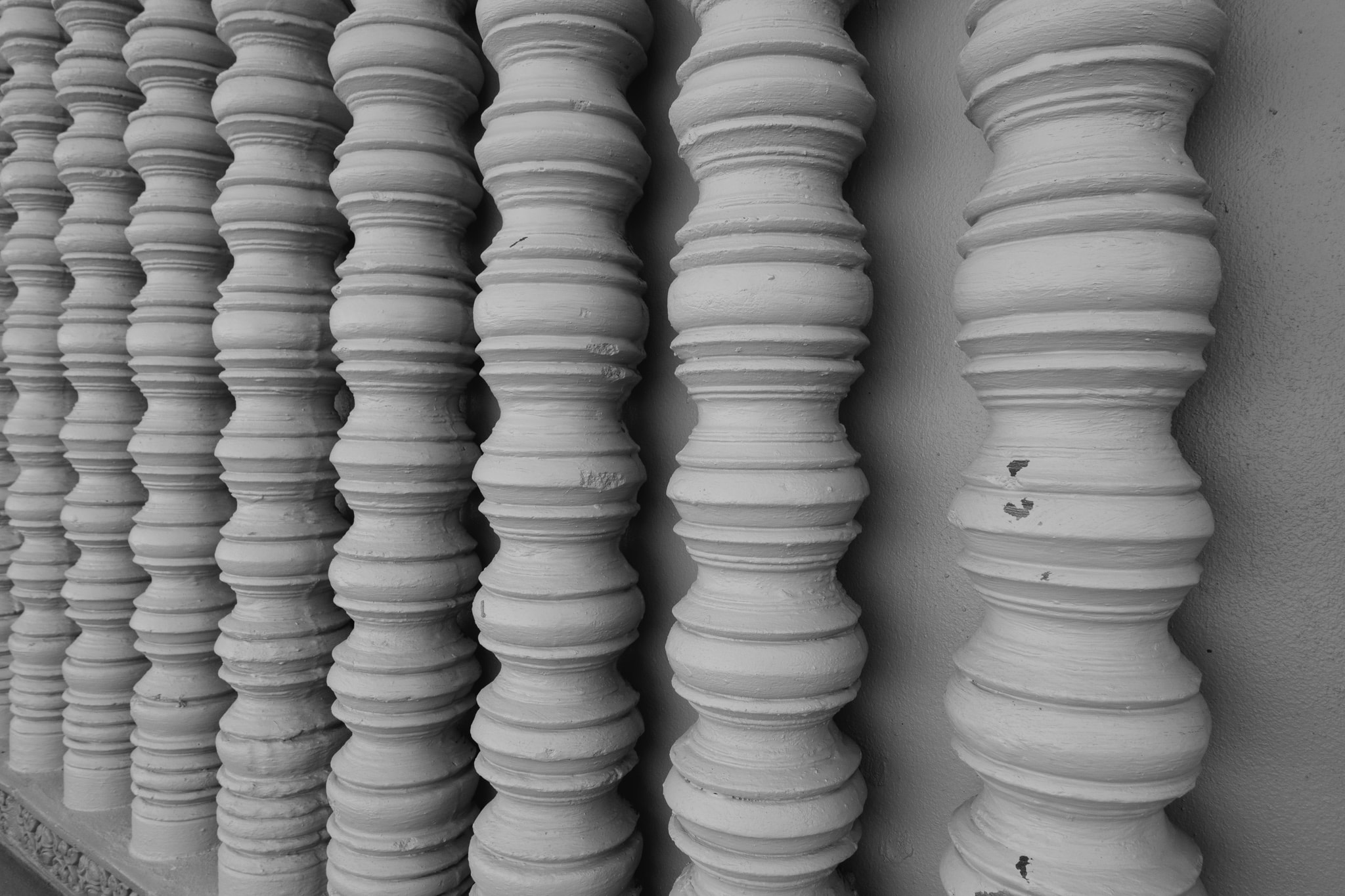 Row of white turned wooden balusters on a building exterior