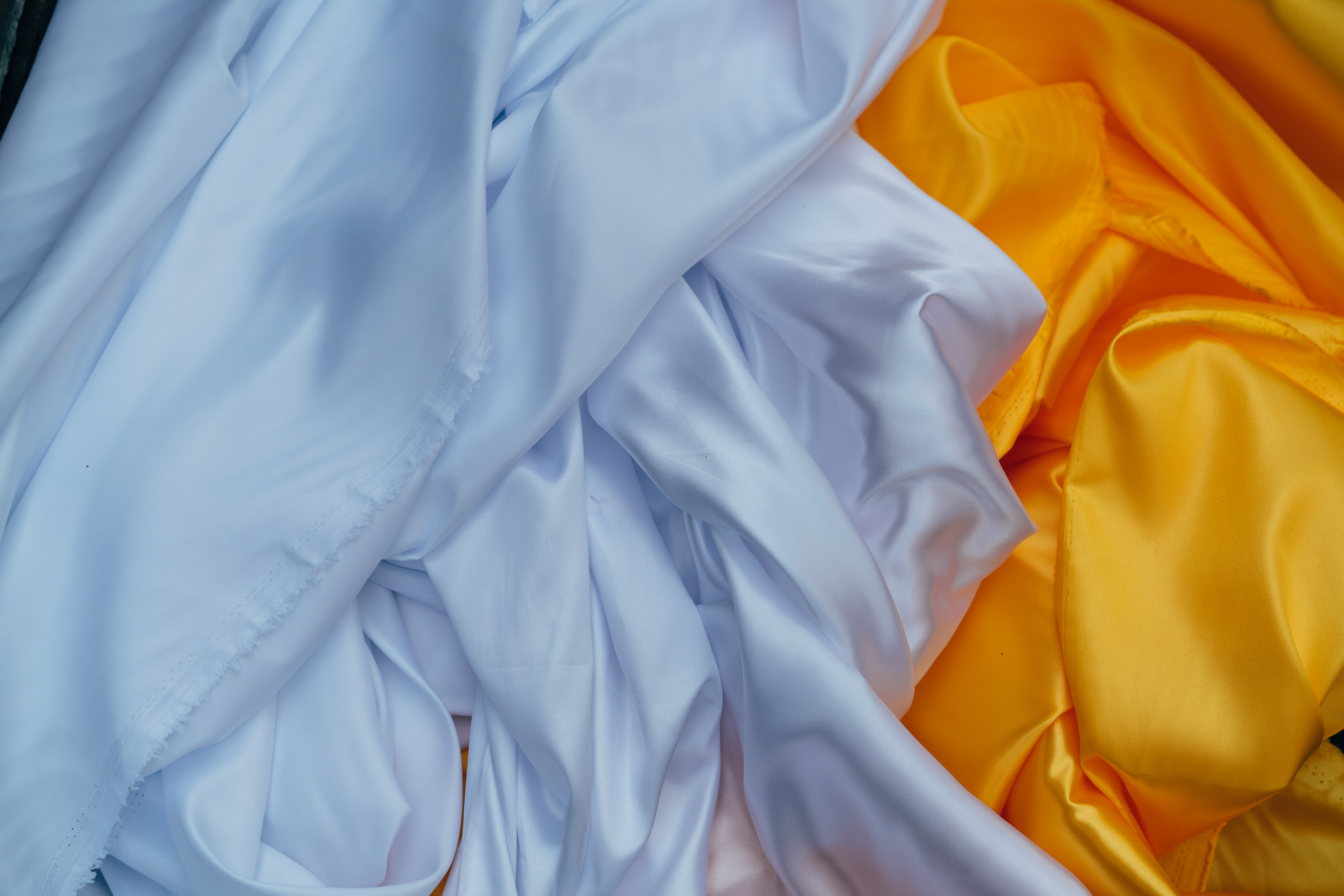 Pile of white and yellow satin fabric