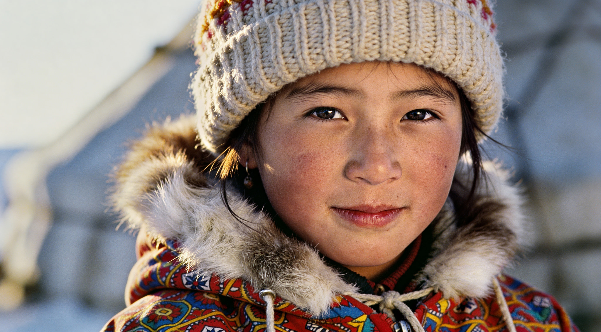 Close-up portrait of a child wearing winter clothing and a knit hat