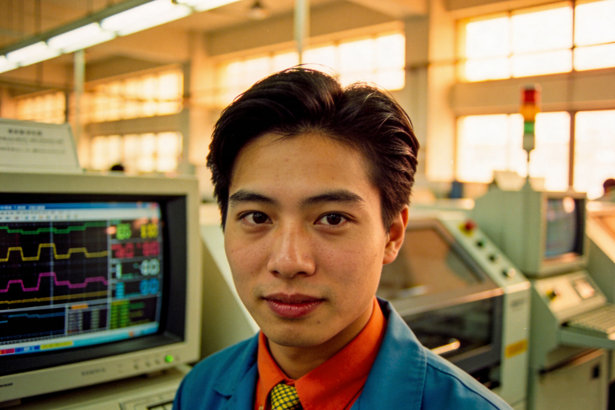 Young male engineer looking at the camera in a factory control room