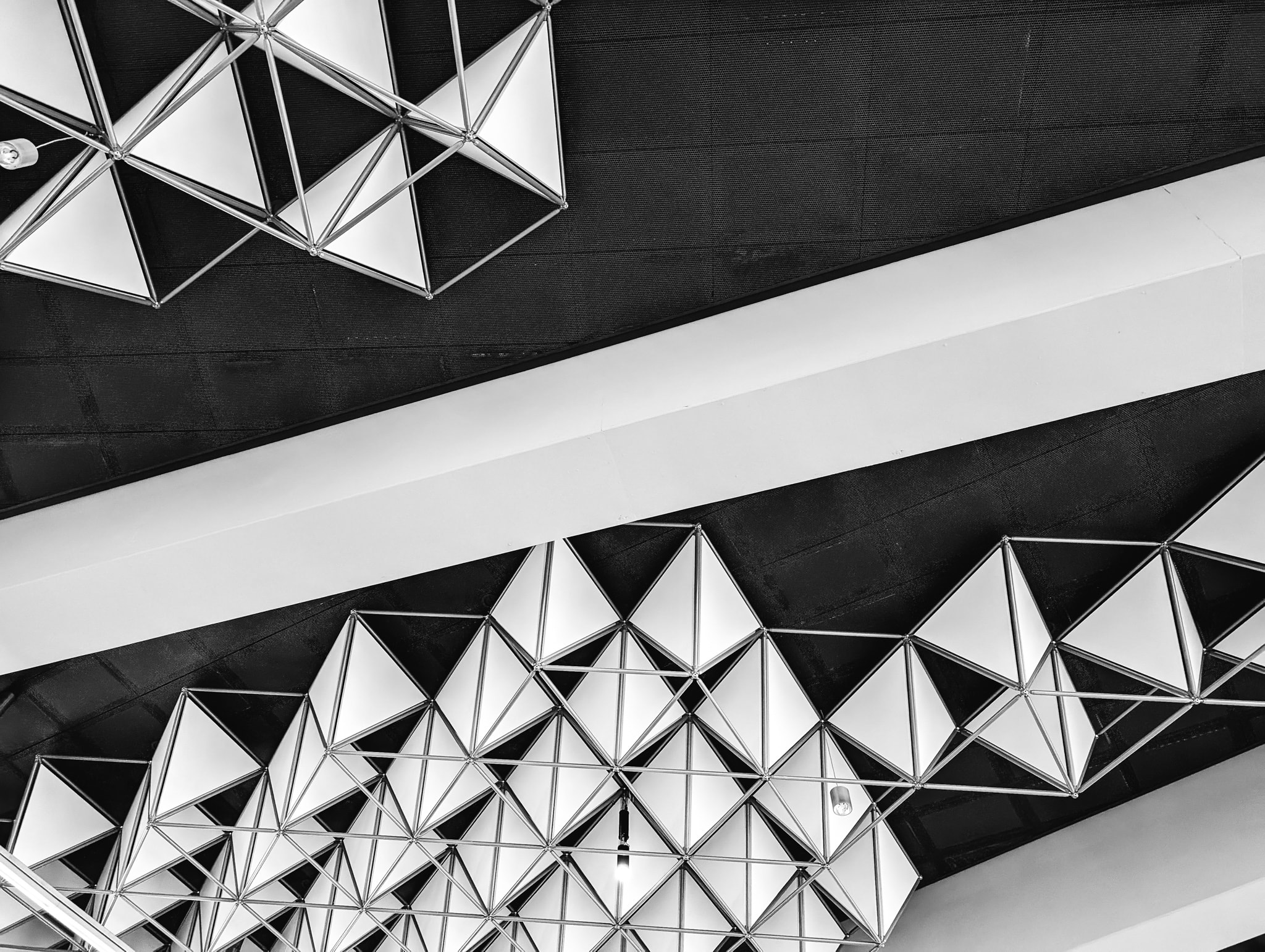 Abstract perspective view of a geometric triangular ceiling installation.